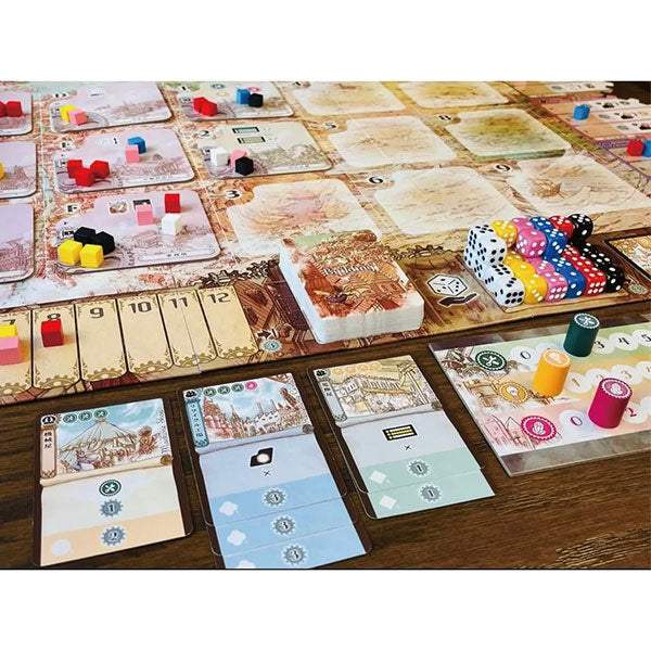 Board game setup with cards, dice, and game pieces on a wooden surface