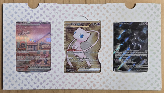 Three trading cards on a patterned card holder with a wooden surface background