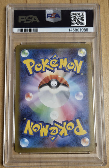 A PSA graded Pokémon card featuring a colorful Pokémon logo and a Pokémon Ball design on the back, sealed inside a clear PSA slab on a light wood surface.