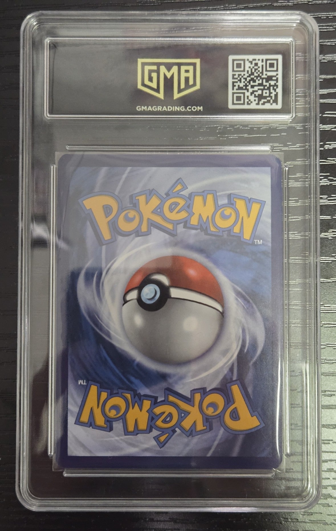 A Pokémon trading card inside a clear graded plastic slab, with the GMA logo and QR code visible at the top. The card back shows the Pokémon name in yellow and a red-and-white Poké Ball illustration on a blue background.