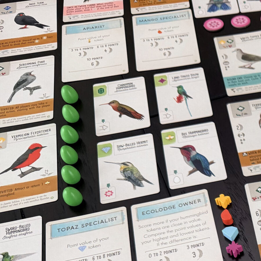 Collection of bird-themed cards and game pieces on a dark surface